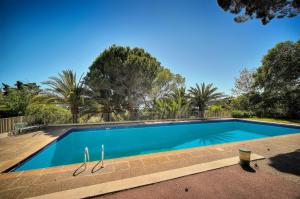 een groot blauw zwembad met bomen op de achtergrond bij Le Greg - Terrasse - Parking - VCA in Cannes