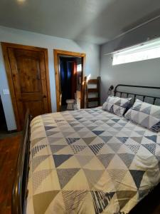 a bedroom with a bed with a checkered blanket at Private, Charming Cabin - Sleeps 5 - The Evergreen - Bryce Canyon National Park in Cannonville