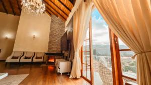 un soggiorno con una grande finestra e un lampadario a braccio di Alben Castle Glenfall a Nuwara Eliya Altre 37 foto