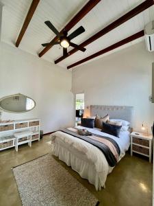 a bedroom with a large bed with a ceiling fan at Hephzibah Inn Signature Farm Cottage in Hermon