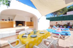 a kitchen and dining room with a table and chairs at Oliver Villa con piscina y aire acondicionado! in Cala'n Bosch