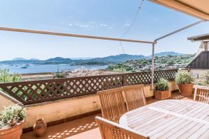 Un patio con una mesa y sillas en un balcón. en Portisco1, en Marina di Portisco