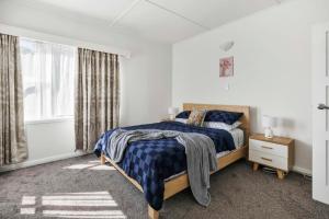 Un dormitorio blanco con una cama y una ventana. en Pukeko Nest Your Kiwi Home in Central Rotorua, en Rotorua