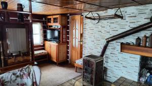 a living room with a fireplace and a television at Villa- Roubenka in Víchová nad Jizerou