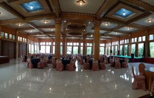 Un salón de banquetes con mesas y sillas en un edificio. en Km 31 Sujono Guesthouse, en Bromo