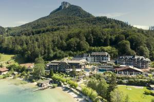 Waldhof Fuschlsee Resort في فوشل ام سي: اطلالة جوية على منتجع جبلي