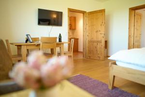 a living room with a table and a room with a bed at BioWeingut & Landhotel Gänz in Hackenheim