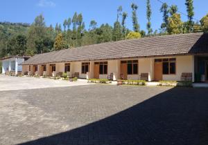 a building with a lot of windows and a roof at Km 31 Sujono Guesthouse in Bromo