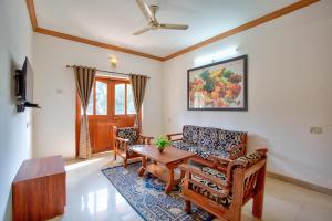 una sala de estar con un sofá y una mesa en Nikita Stay Goa, en Calangute