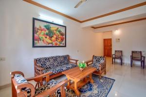 Una sala de estar con un sofá, una mesa y sillas. en Nikita Stay Goa, en Calangute