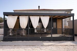 a screened in porch with white curtains on a house at Mobile home Maslina Sveti Petar na Moru in Sveti Petar