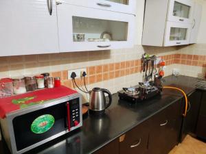 een keuken met een fornuis en een magnetron bij Exclusive Floor on Manali Expressway for Family in Mohali +33 foto's