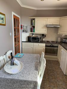 une cuisine avec une table, des chaises et un comptoir dans l'établissement Golf Cottage, à Gullane
