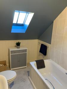 a bathroom with a bath tub and a skylight at Golf Cottage in Gullane