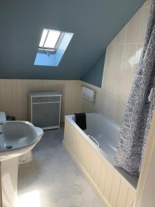une salle de bain avec une baignoire et un lavabo dans l'établissement Golf Cottage, à Gullane
