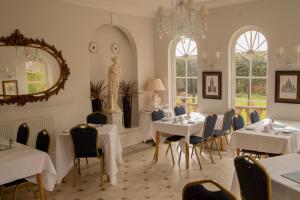 a dining room with tables and chairs and a statue at Aylestone Court in Hereford