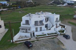 una casa blanca con dos coches aparcados delante de ella en Easy Living Tinos, en Vrachonisída Chántra
