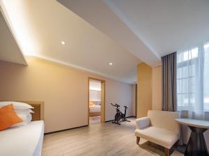 a bedroom with a bed and a table and a chair at 天门山云尚景豪酒店 in Zhangjiajie