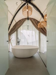 クチンにあるCocoon Resort Kuchingの窓付きのバスルーム(大きな白いバスタブ付)