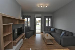 Una sala de estar con un sofá y un televisor. en Easy Living Tinos, en Vrachonisída Chántra