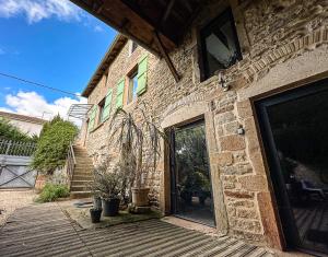 a brick building with a door and a patio at Le clos de Laly in Charnay-lès-Mâcon