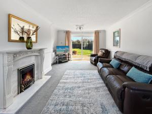 a living room with a couch and a fireplace at Amaya Nine Sleeps 7 Large 4 bed house - Bottesford in Bottesford