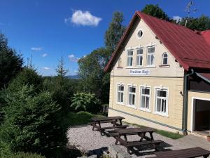 a building with picnic tables in front of it at Penzion Hají in Janov nad Nisou