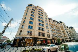 a tall building with cars parked in front of it at Eminescu Residence! in Chişinău