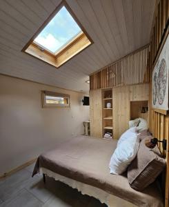 a bedroom with a large bed with a skylight at maison avec studio independant dans le centre de soulac - 5306 in Soulac-sur-Mer