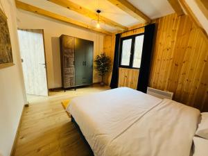 a bedroom with a white bed in a room with wooden walls at A-frame Marisa Vadu Crisului in Vadul lui Carol II +34 photos