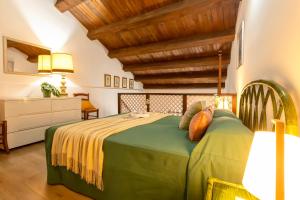 1 dormitorio con cama verde y techo de madera en SARDINIA RE - Loft Antica Italia, en Sassari