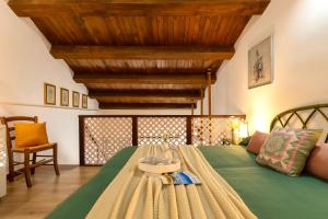 1 dormitorio con cama verde y techo de madera en SARDINIA RE - Loft Antica Italia, en Sassari