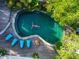 an overhead view of a swimming pool with a person in the water at Ecozy Dijiwa Canggu in Canggu