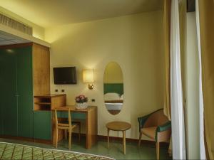 a room with a bed and a table and a mirror at Hotel Cristallo in Giulianova
