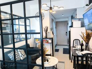 a room with a large window and a table and chairs at Casa Lolanthe Fully Furnished Studio Unit in Pasong Bayog