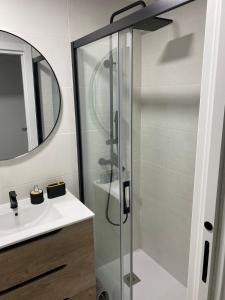 a bathroom with a glass shower and a sink at El salon de los abuelos in Trescasas
