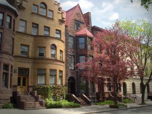 a large brick building with a tree in front of it at Morgan State House Inn in Albany