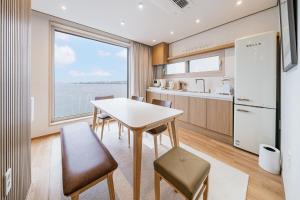 a kitchen with a table and chairs and a large window at Cony Ocean Suite Hotel in Jeju