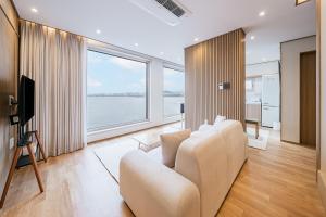 a living room with a white couch and a large window at Cony Ocean Suite Hotel in Jeju