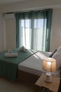a bedroom with a bed with towels and a lamp at Golden sand apartment A in Hersonissos