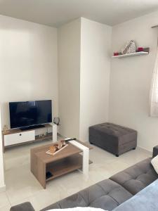 a living room with a couch and a tv at Golden sand apartment A in Hersonissos