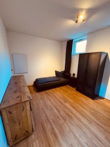 エアフルトにあるSteinplatz Studioのウッドフロアのリビングルーム(ソファ付)