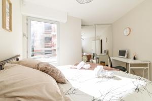 a white bedroom with a large bed and a desk at Nice Luxury in Nice