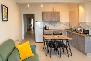 a kitchen with a table and chairs and a refrigerator at GREEN n' BLUE apartments in Kalamaki