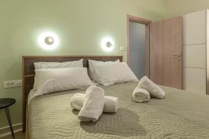 a bedroom with a bed with towels on it at GREEN n' BLUE apartments in Kalamaki +53 photos
