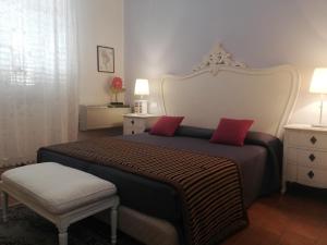 a bedroom with a large bed with two red pillows at Residenza Levante in Siracusa