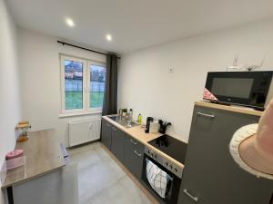 a kitchen with a sink and a tv on the wall at Charming 2-room apartment in Halberstadt