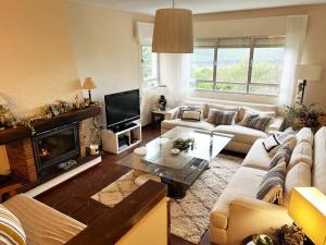 a living room with a couch and a fireplace at Increible casa de campo, 5 DORM, MARCO INCOMPARABLE in Pareja