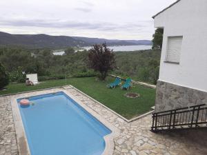 a swimming pool with two chairs and a house at Increible casa de campo, 5 DORM, MARCO INCOMPARABLE in Pareja