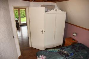 a large white cabinet in a room with a bed at Spotvogel I Vacation Home in Zwiggelte